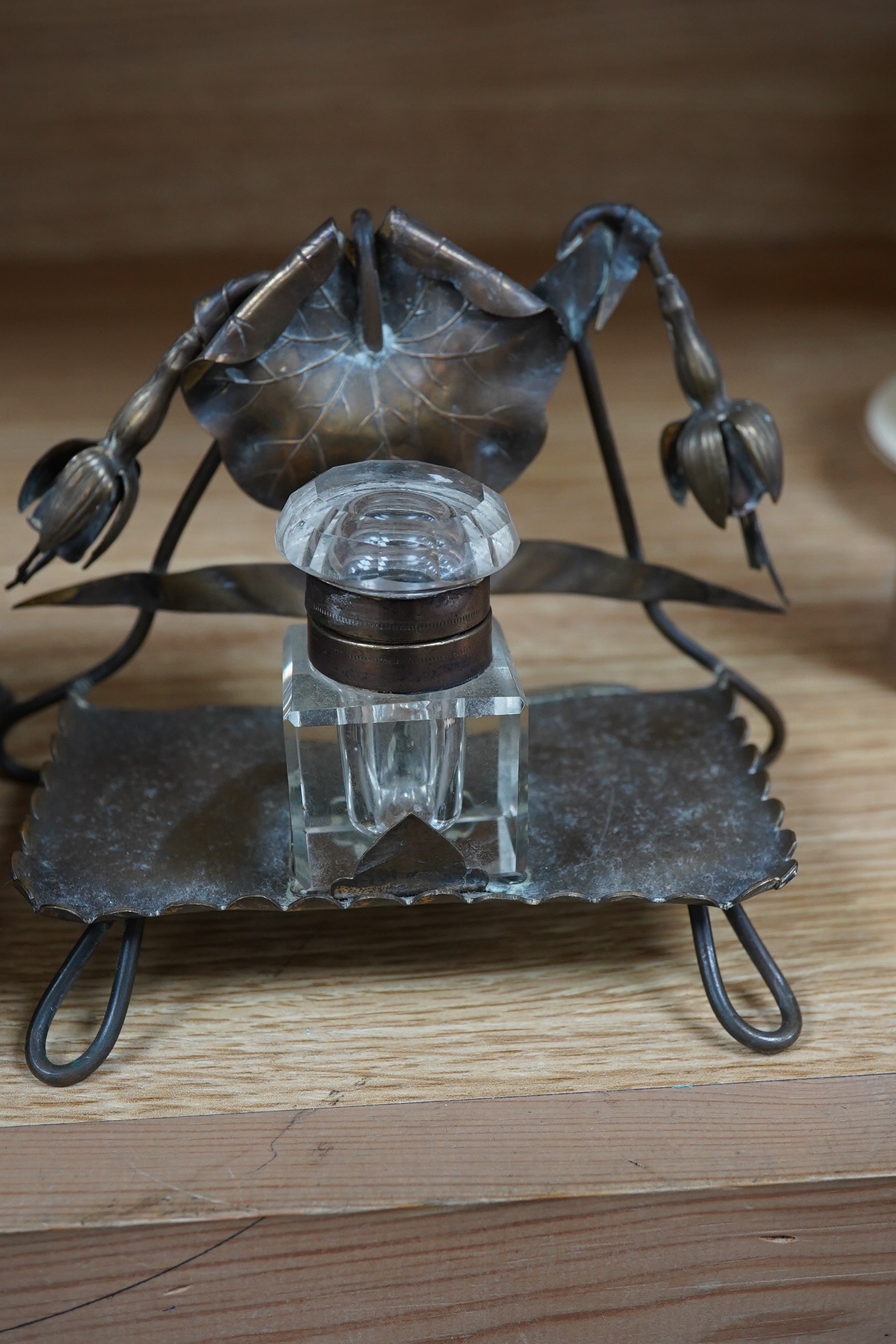 A Georgian pewter standish, 18cm wide, and an inkwell on a brass frame in the form of a fuchsia. Condition - fair